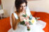 Morning of the bride. Beautiful smiling brunette bride in a white dress with a wedding bouquet in her hands.